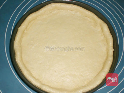 披萨盘刷油;取一面团擀成均匀的圆形,铺入披萨盘中,并将周圈推厚