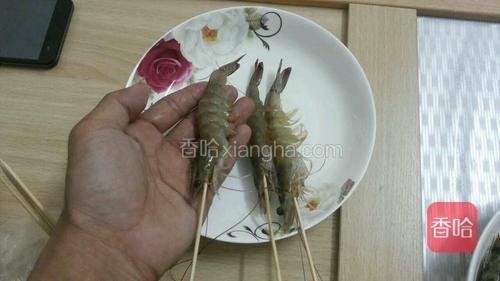 用竹签将虾一个一个从头至尾刺入，让虾成条状，不但美观，还易包锡纸，吃时也方便。