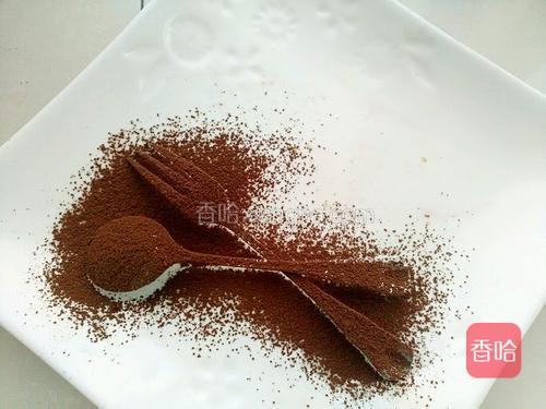 取<br/>少许可可粉。用小刀和叉子放在盘里。用个小筛子过筛就可以。在取出小勺子和叉子。把做好的西多士摆好就可以了。