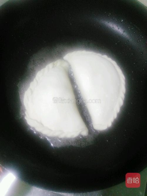 取一口不粘锅，锅里放少量的油，把做好的韭菜盒子，放入锅里，小火慢慢的煎烤。