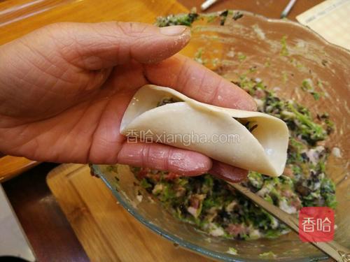 对折饺子皮,捏紧中间部位。