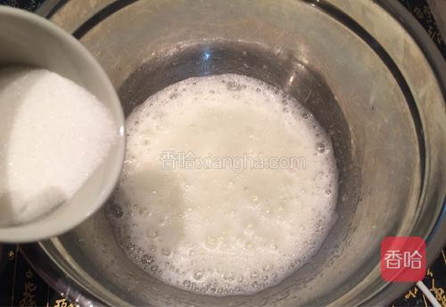 在蛋白盆里加几滴柠檬汁，用电动打蛋器低速搅打至蛋白泡沫呈鱼泡眼状时，加入1/3细砂糖；