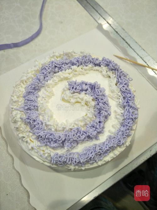 用紫色奶油按照画好的形状挤出奶油,再用白色奶油把控的地方挤出白色