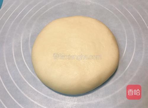 翻转放在硅油纸上，稍微压扁整理成大饼形状，移至烤盘中。