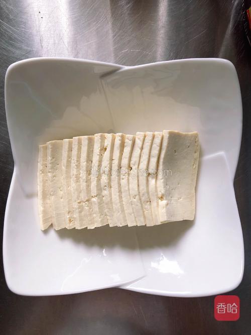 将豆腐切成片状，摆入盘中。