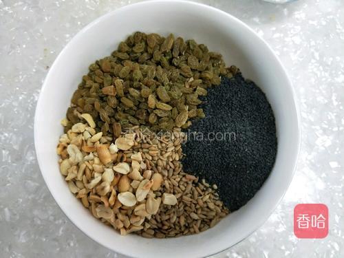 将果仁放入大点的容器里，加入50克糯米粉，蜂蜜和花生油。